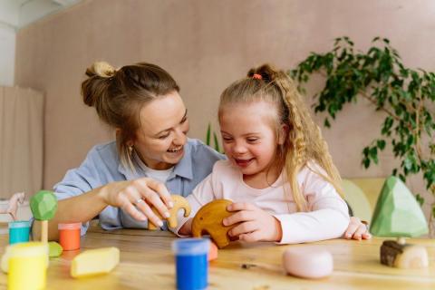 Mom and daughter playing with wooden toys.