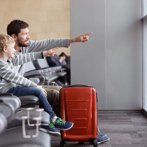 Father and child sit together at the airport.